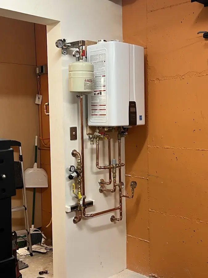 Plumbing technician inspecting water heater connections in Camden